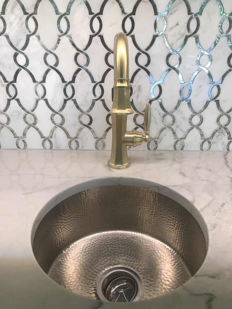 A bar sink with patterned tile.