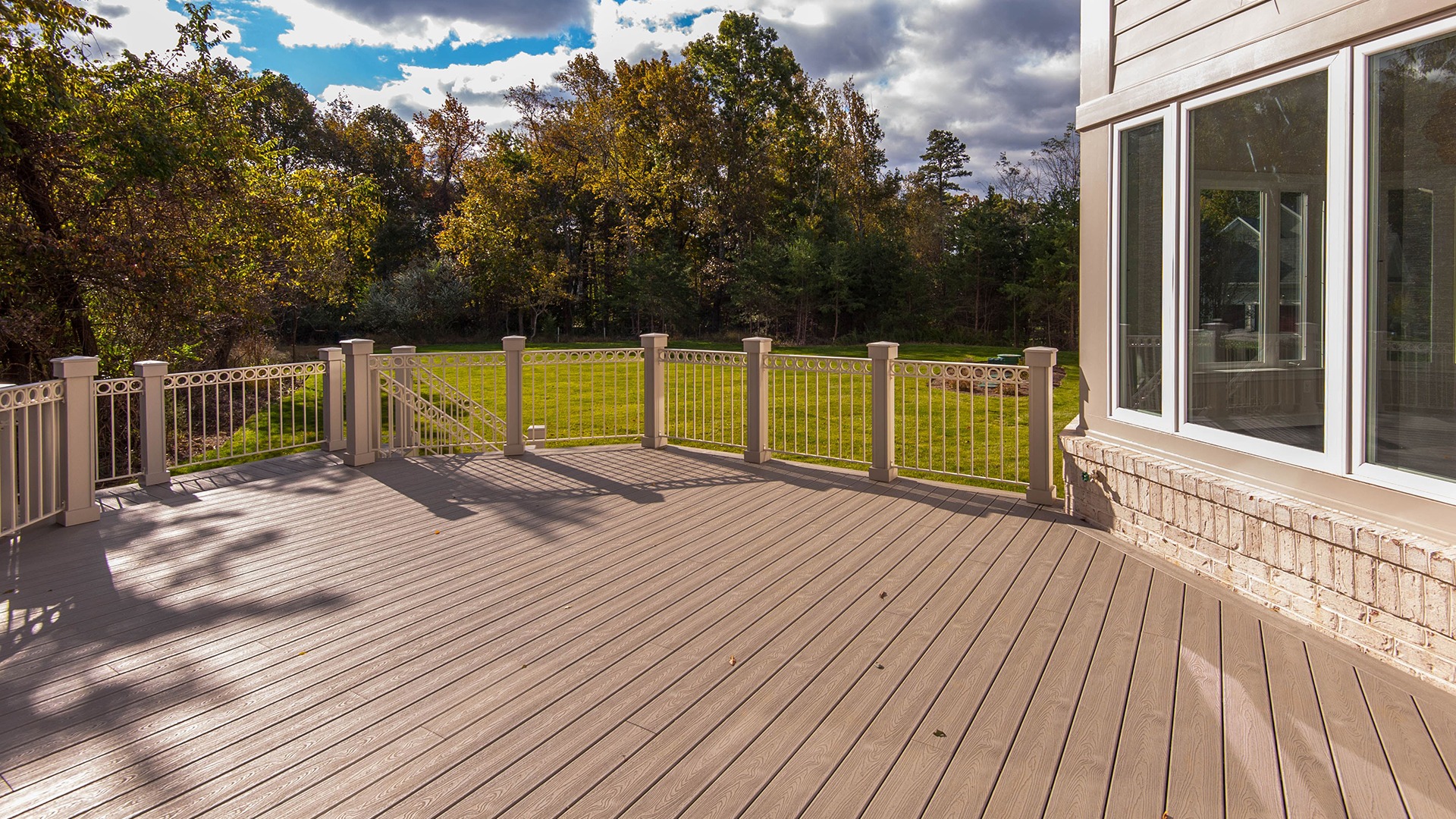 A custom designed composite deck with a beautiful view of the rear year.