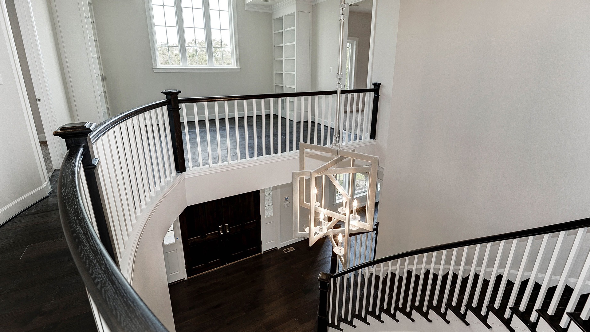 The impressive foyer with dramatic curved stair.